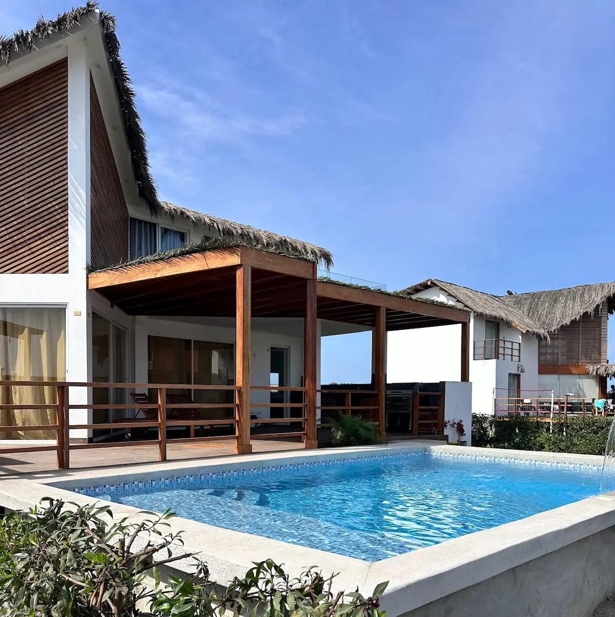La piscina de día con la terraza techada detrás